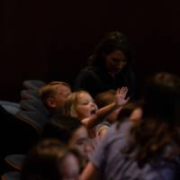 stuent clap in audience, dark auditorium